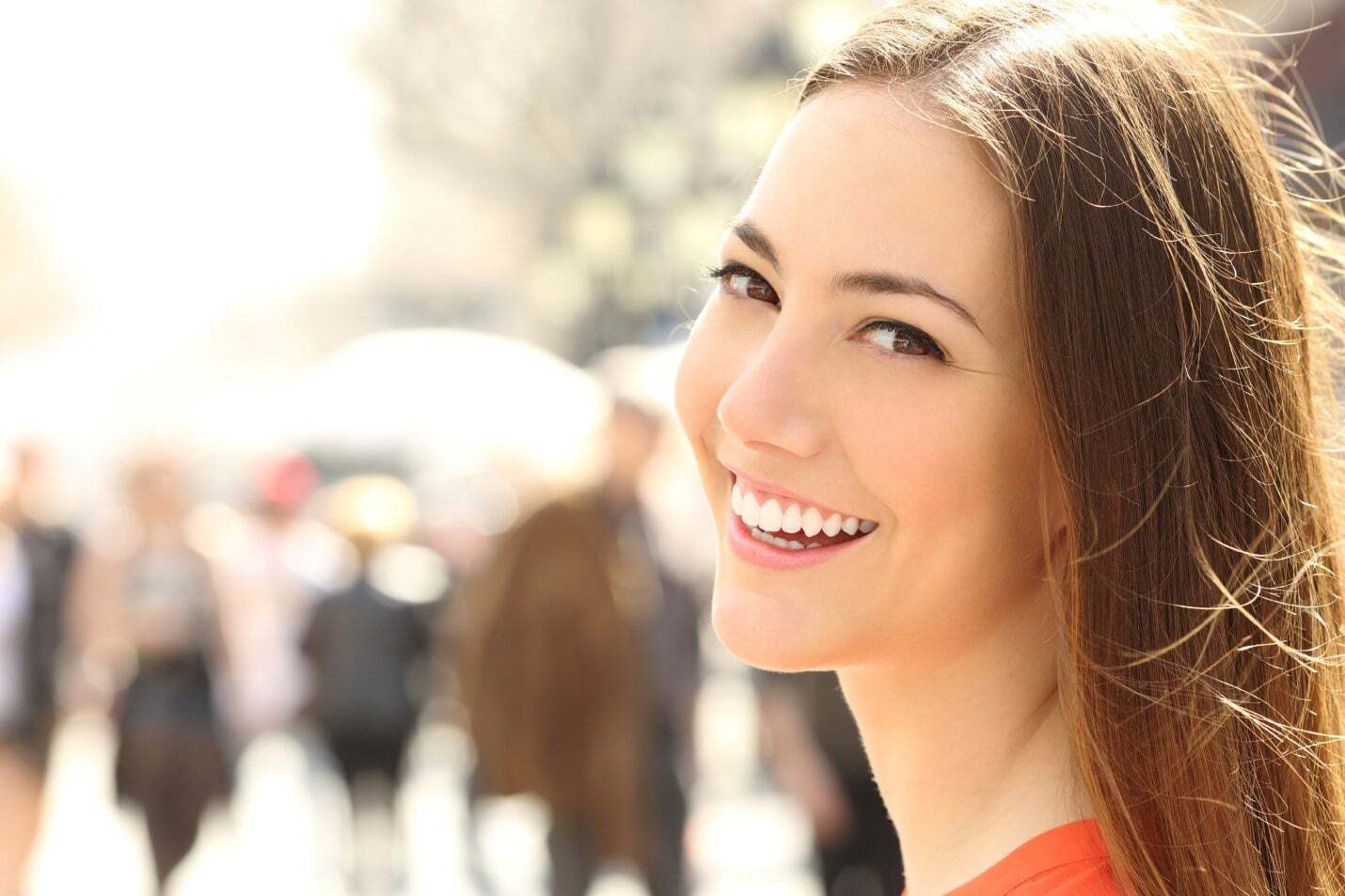 Happy woman with a bright white smile in an urban setting.