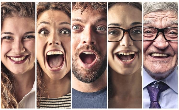 Five people of different ages smiling brightly at the camera, showing healthy teeth and genuine expressions.