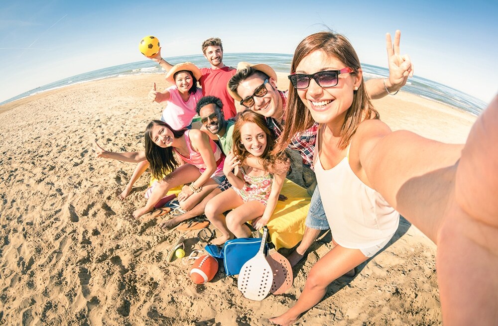 Group of smiling young people enjoying summer beach day in Corpus Christi.