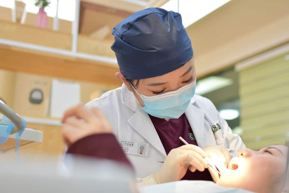 Dentist performing oral examination on patient in Corpus Christi dental office.