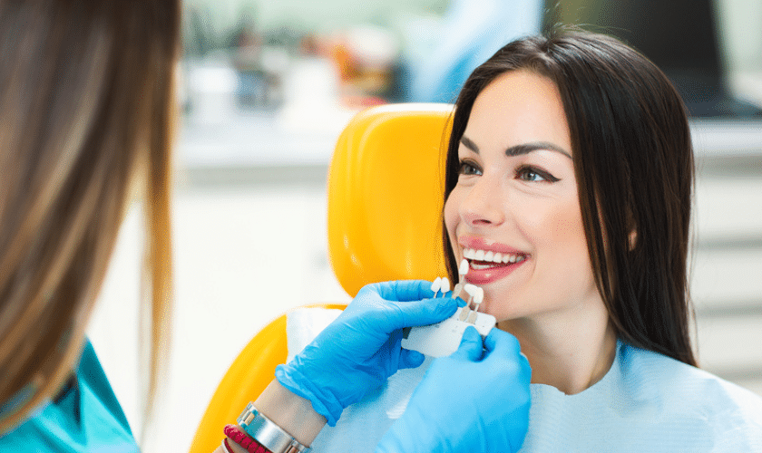 Dentist examining patient's teeth during cosmetic smile makeover consultation.