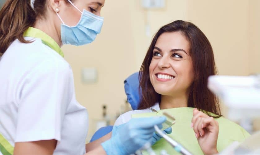 Dental hygienist consulting with smiling patient about implant care in Corpus Christi.