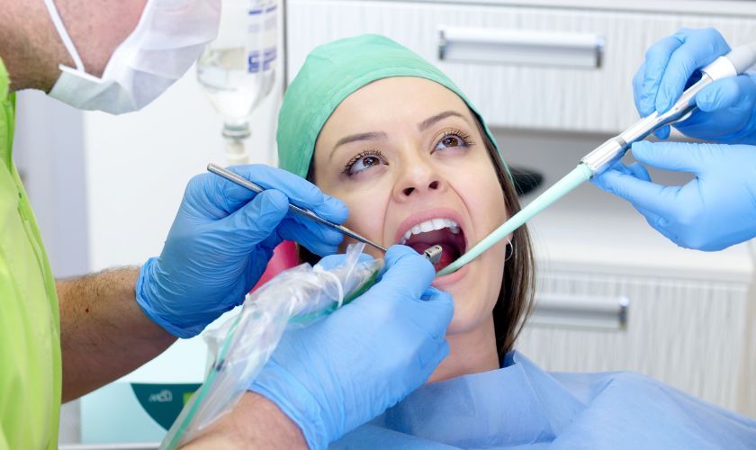 Dental professional examining patient's teeth during implant consultation in Corpus Christi office.