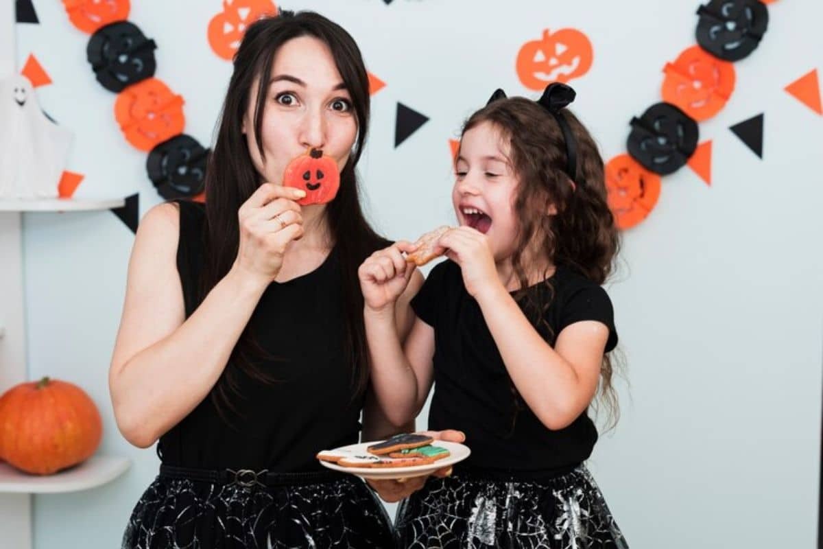Mother and daughter enjoying Halloween treats while practicing dental health awareness.