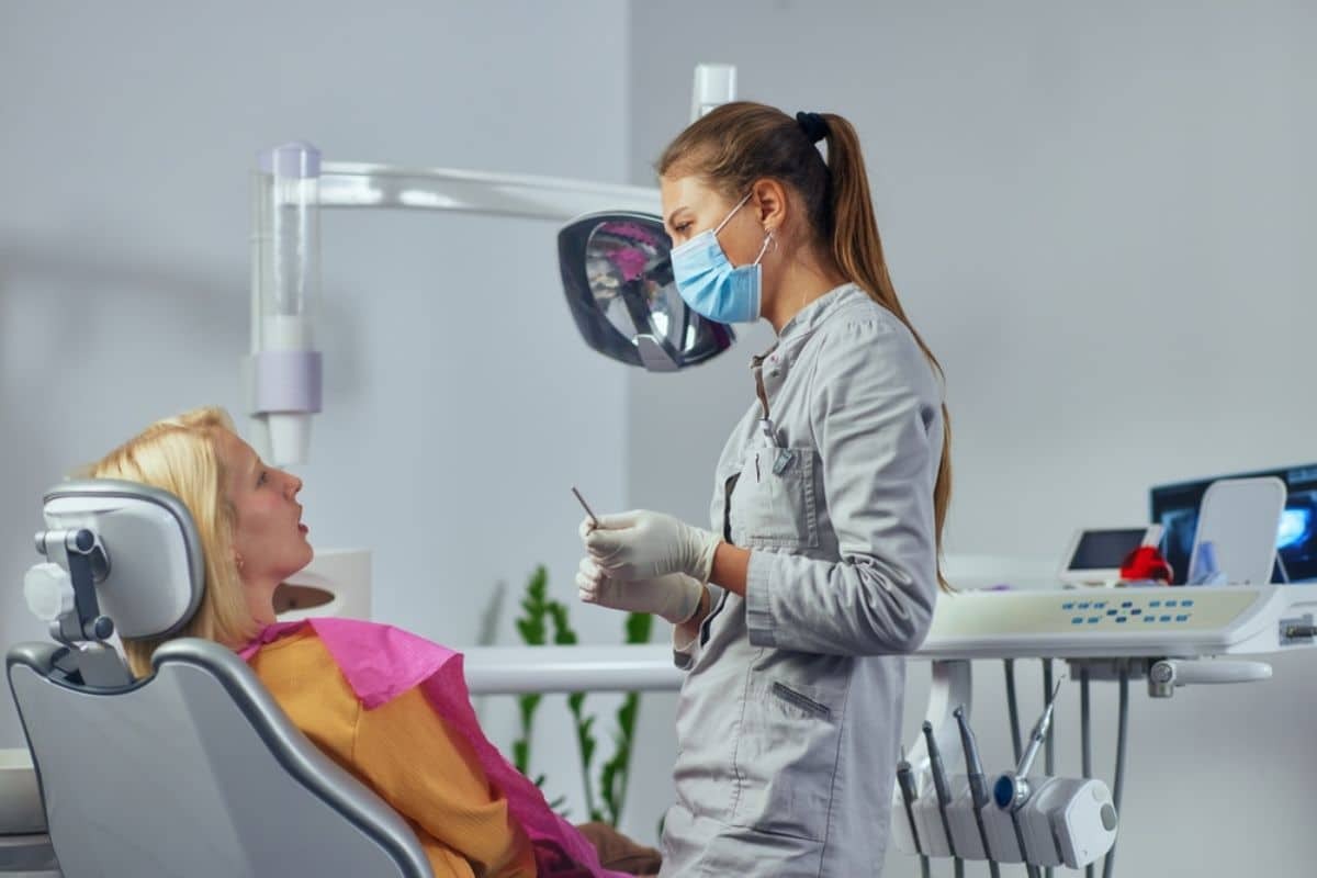 Female dentist examines patient in modern Corpus Christi dental office with intraoral camera.