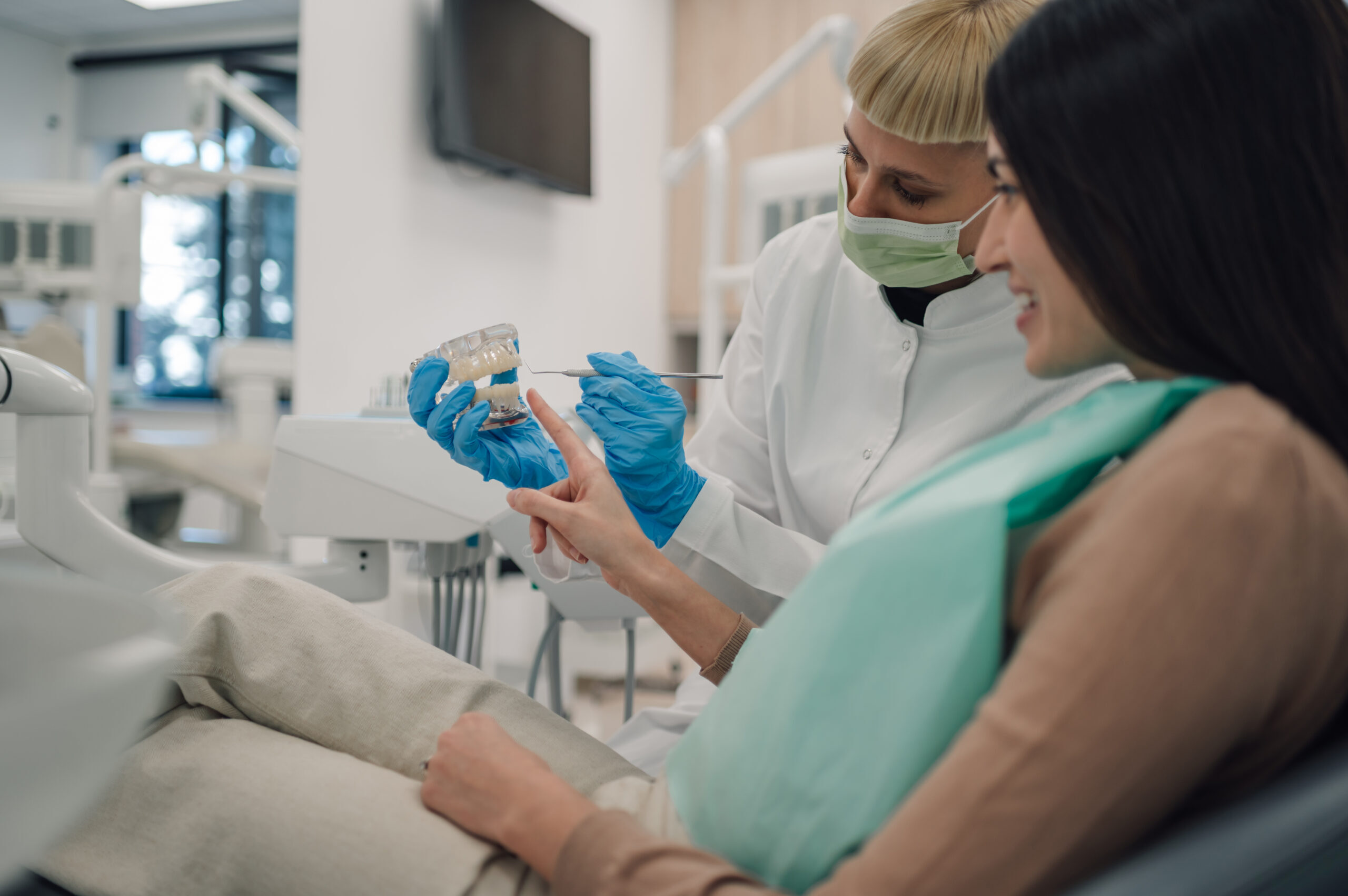 Dentist showing dental model to patient during implant aftercare consultation in Corpus Christi.