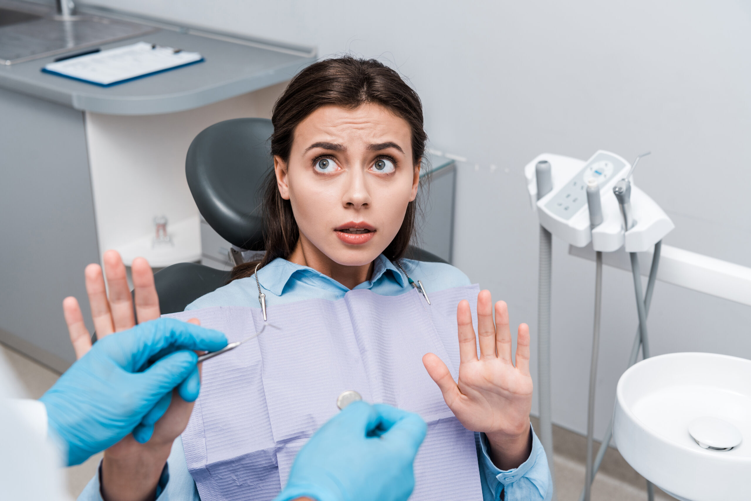 Nervous dental patient showing anxiety during consultation in treatment room.