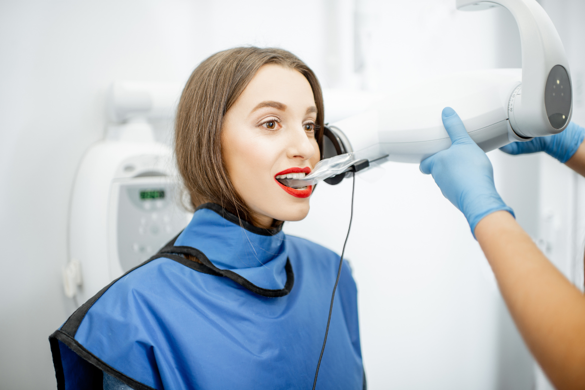 Dentist using intraoral scanner to examine patient's teeth during dental treatment.