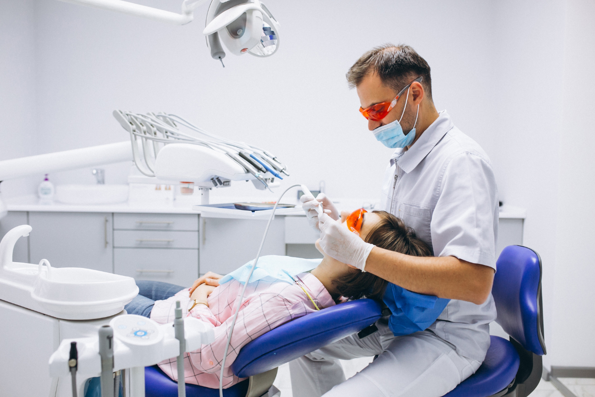 Dentist treating young patient in modern dental office with advanced diagnostic equipment.